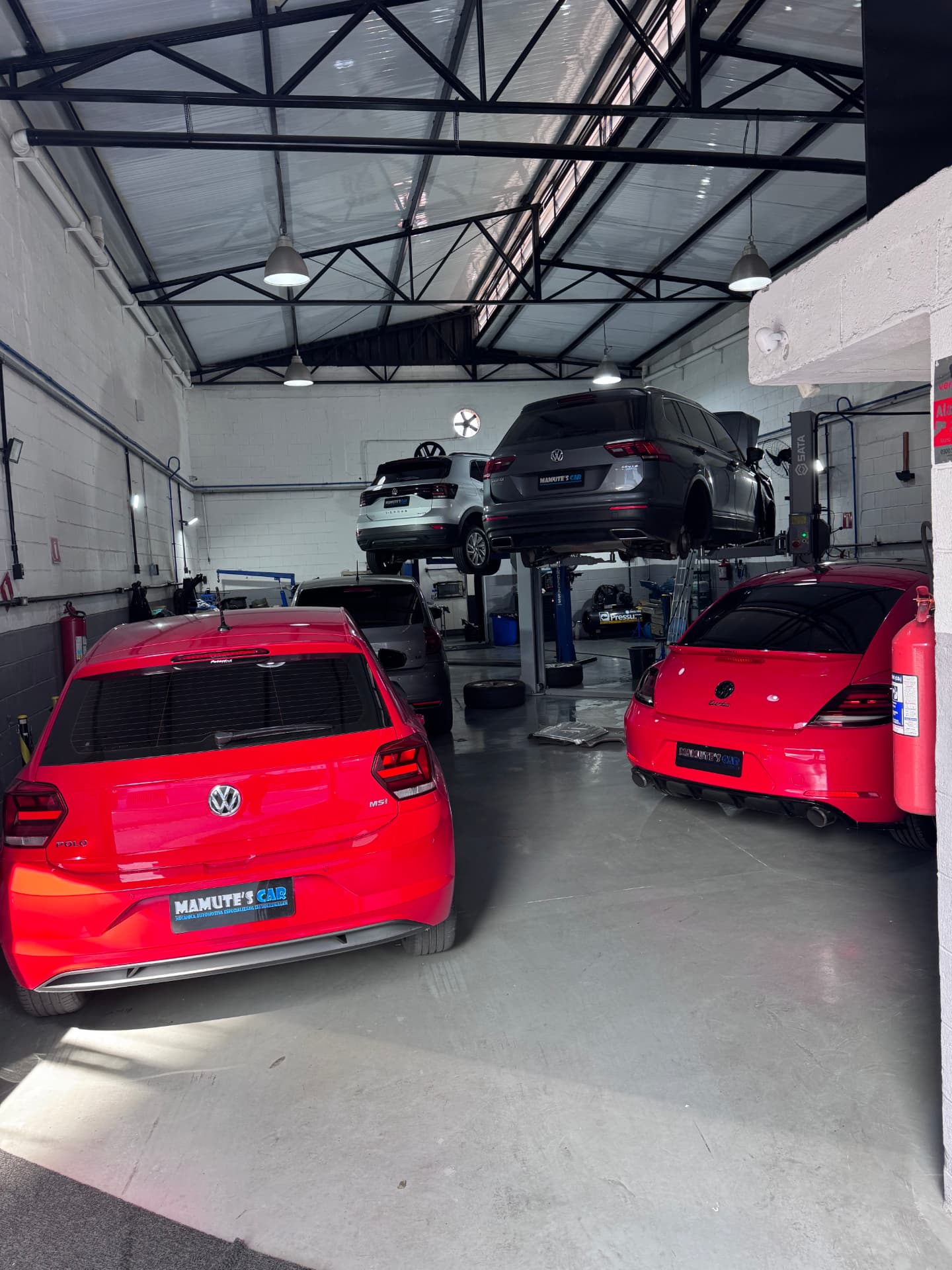 Volkswagen Polo e Fusca no salão da oficina